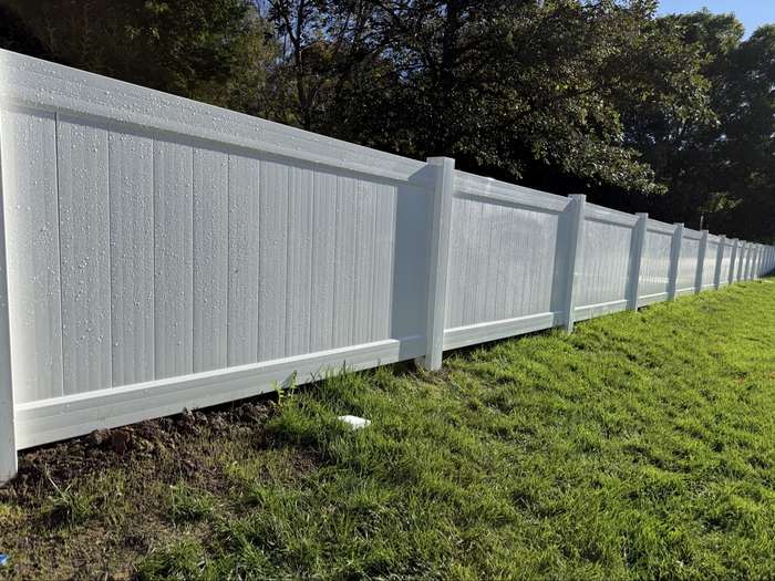 White vinyl privacy fence in a backyard